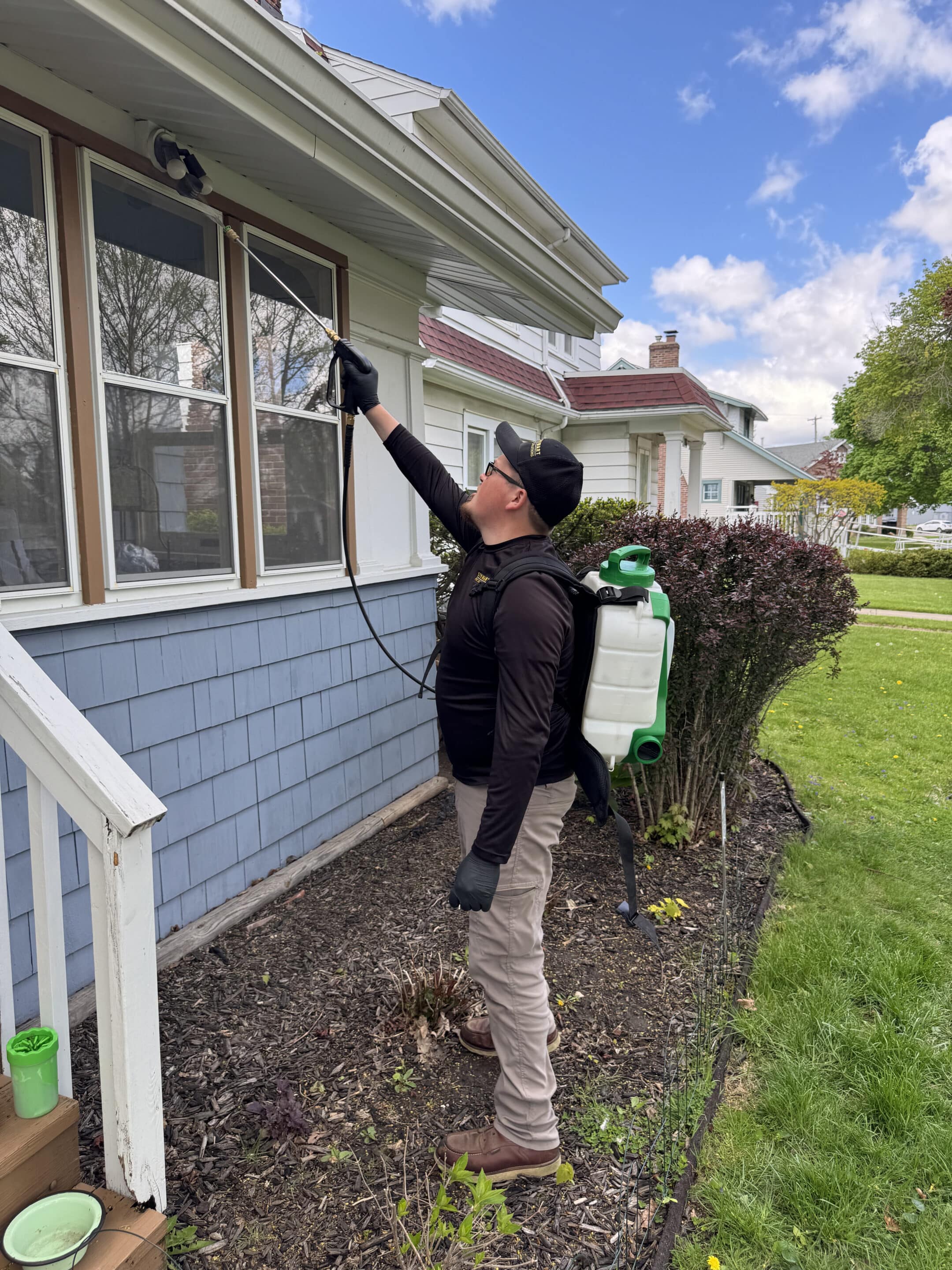 pest control worker spraying house